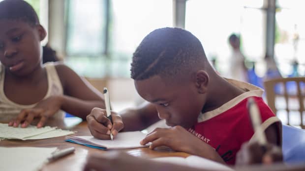 boy doing schoolwork at table