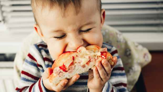 toddler eating pizza